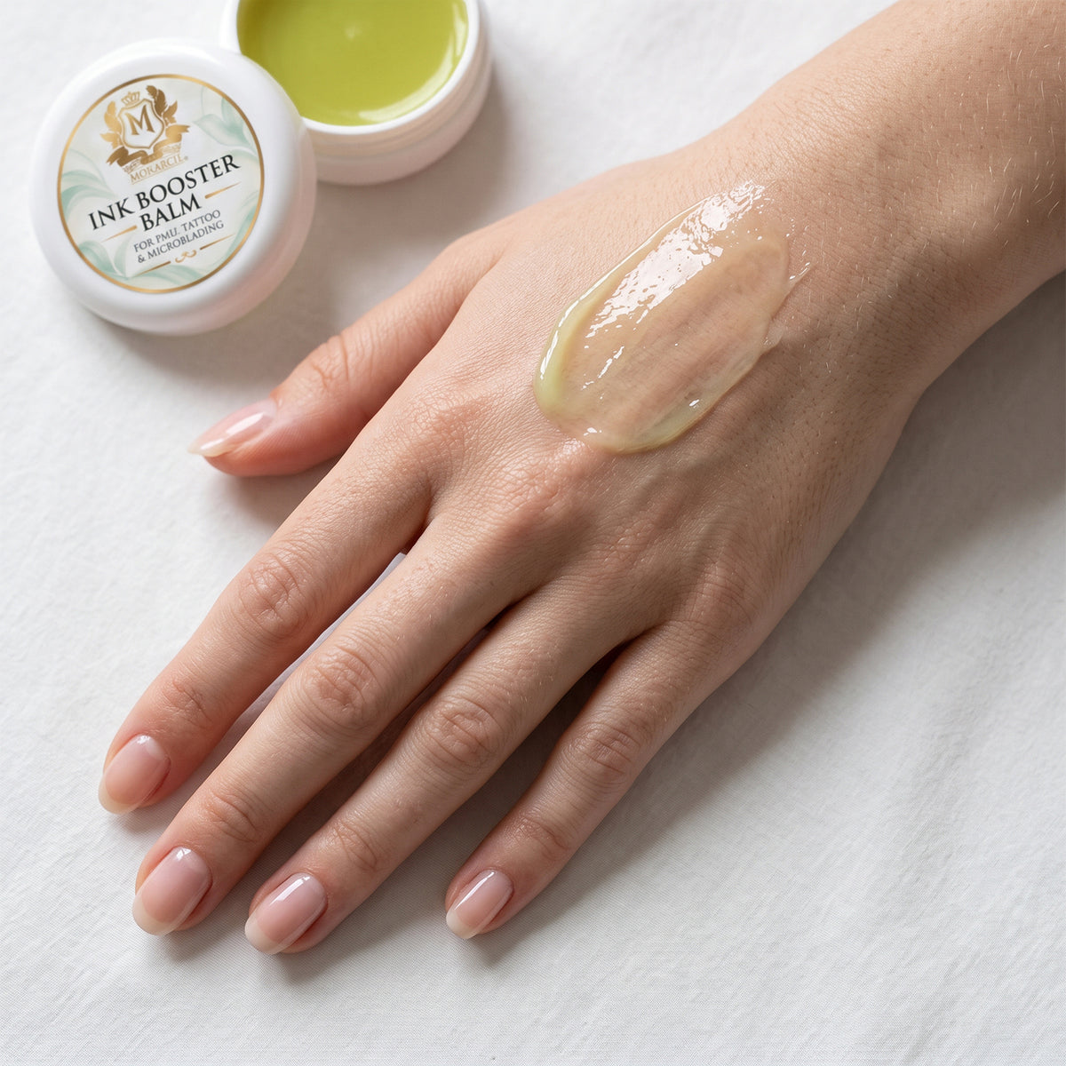 Skin Monarch Ink Booster Balm 30ml, bálsamo brilhante espalhado no dorso de uma mão